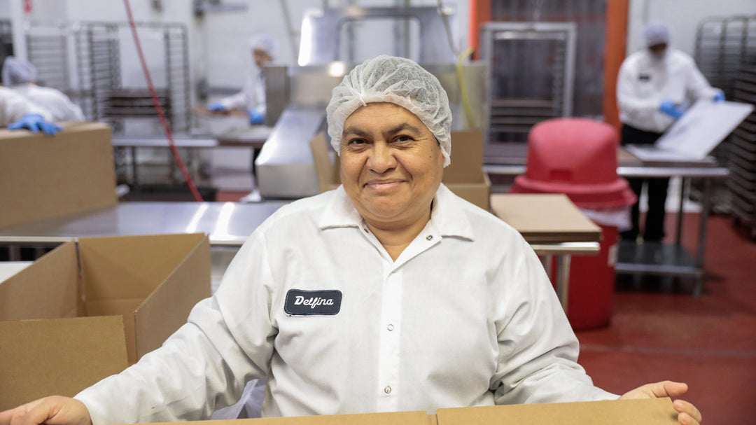 Greyston Bakery employee smiling at the camera while working in the bakery